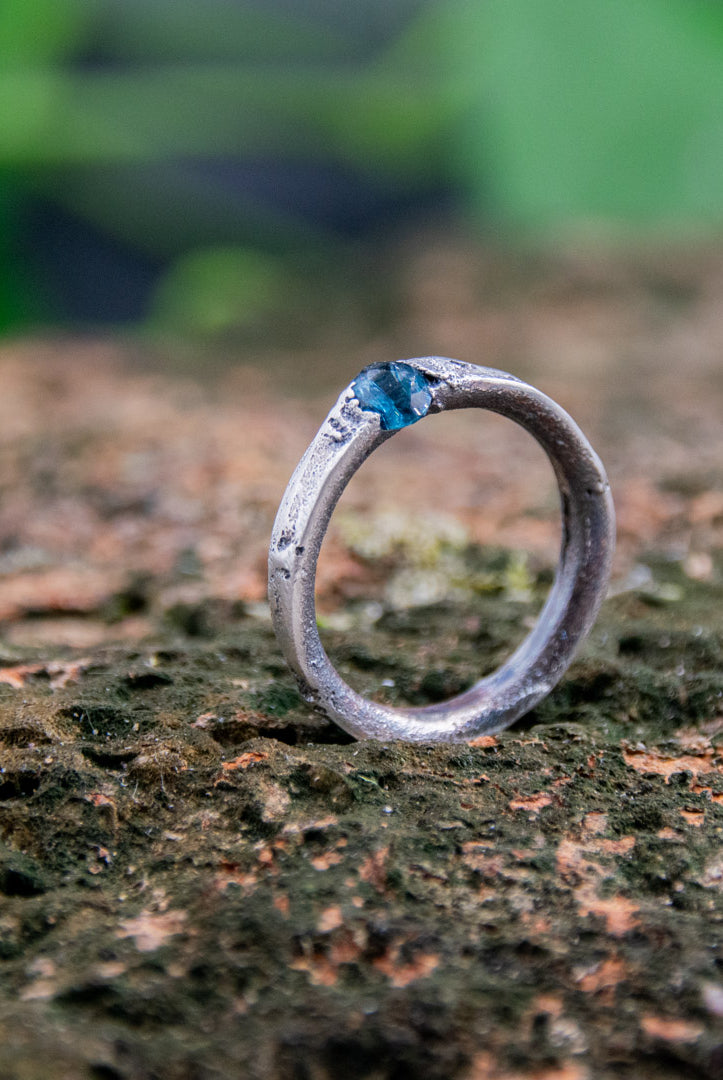 Unique blue sky zirconia sand casting ring on textured stone background, showcasing artisanal craftsmanship.