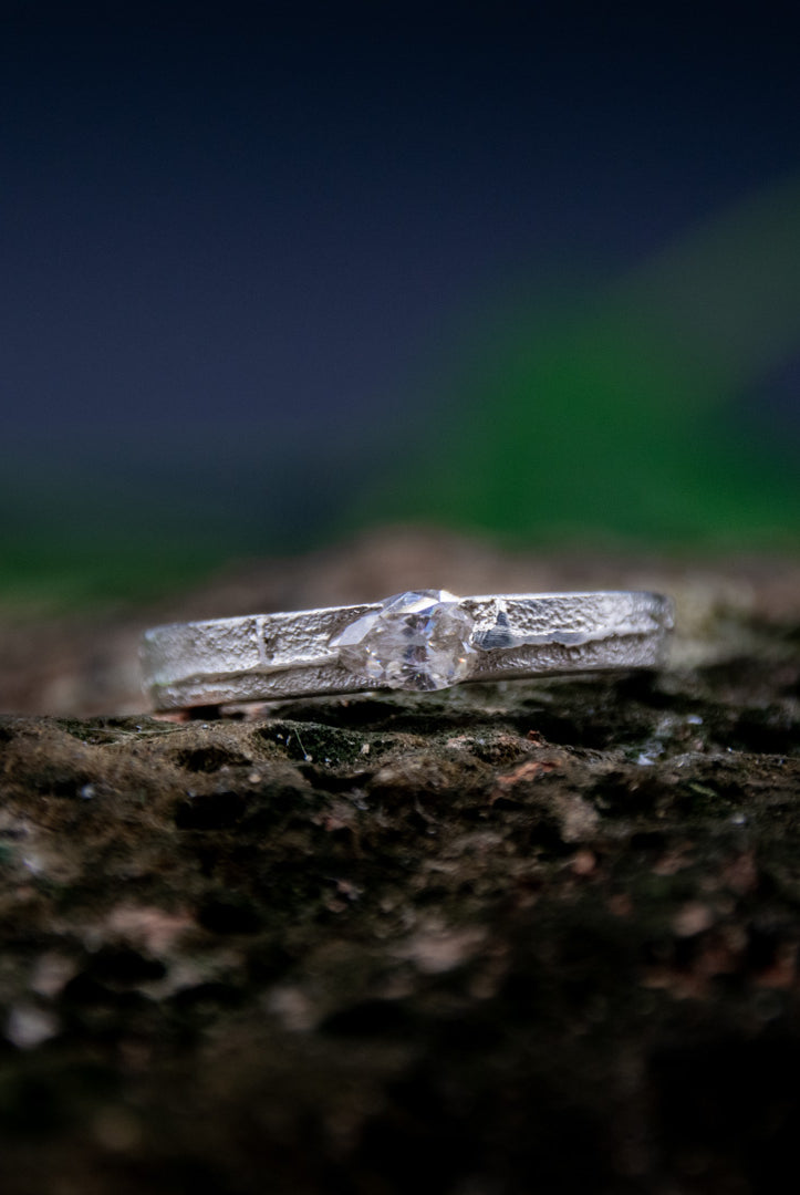 Crystal zirconia sandcasting ring showcasing unique organic textures and artisanal craftsmanship in a natural setting.