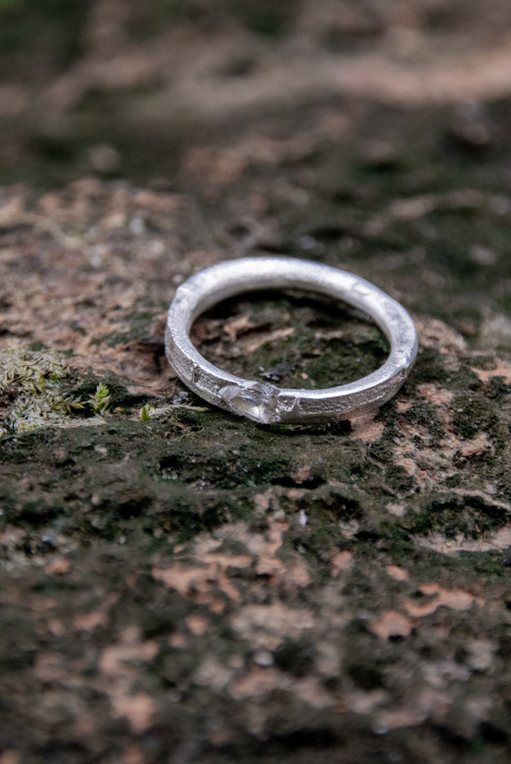 Crystal zirconia sand casting ring showcasing unique organic texture and irregular shape on textured surface.