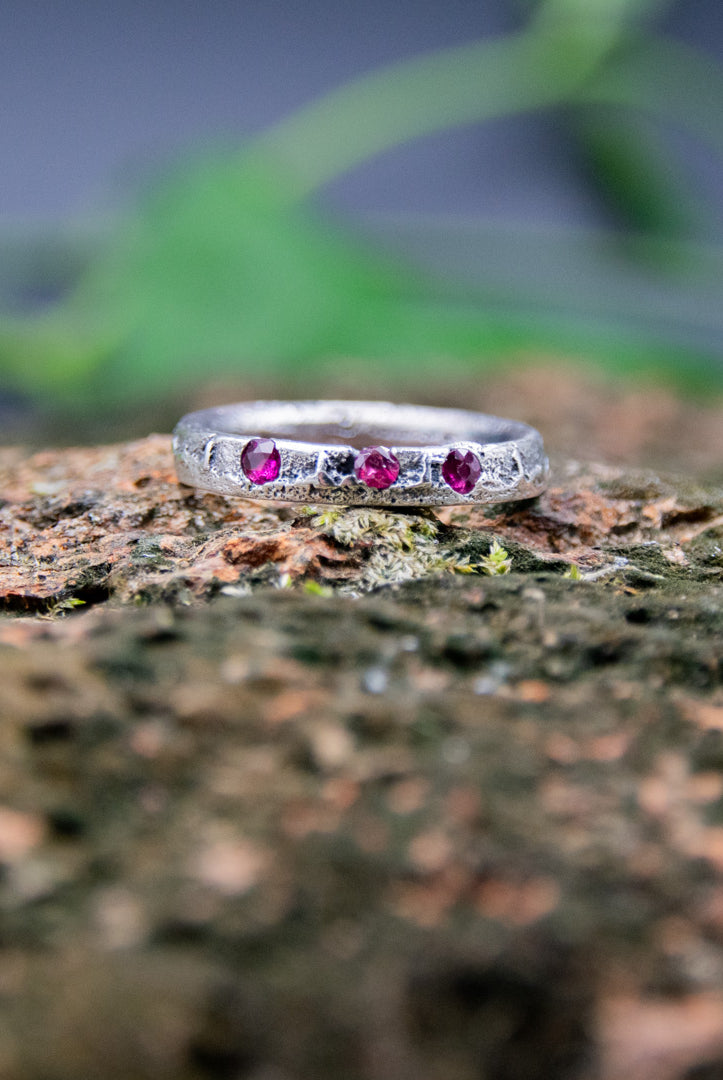 Three Little Ruby Sand Casting Ring showcasing unique textures and artisanal craftsmanship on a natural background.