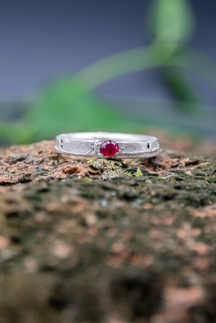 Unique round ruby sand casting ring showcasing artisanal craftsmanship and organic textures.