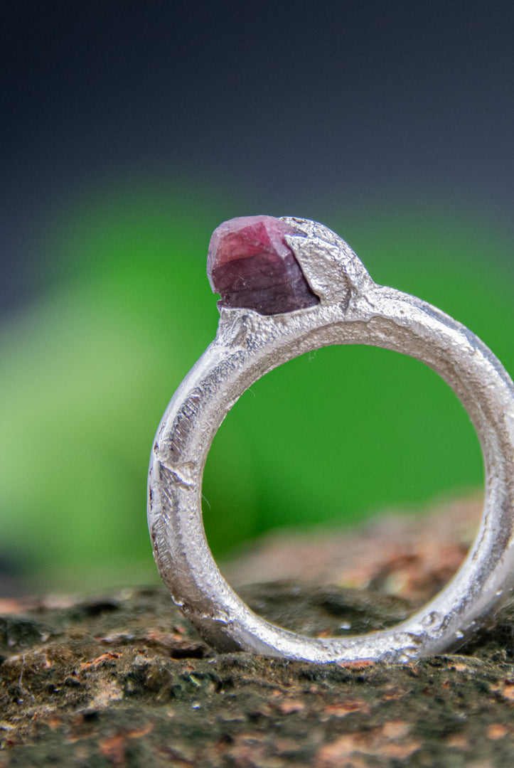Raw ruby round ring in sand cast silver, showcasing organic texture and one-of-a-kind design.