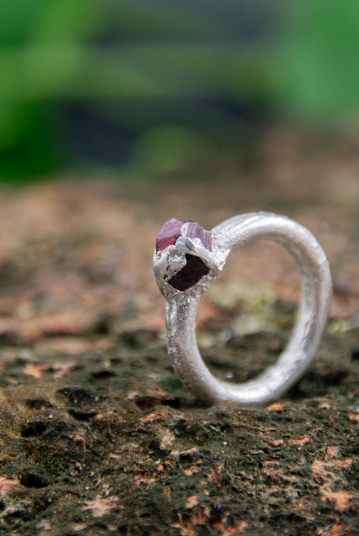 Raw ruby round ring in sand-casted silver, showcasing unique organic textures and imperfections.