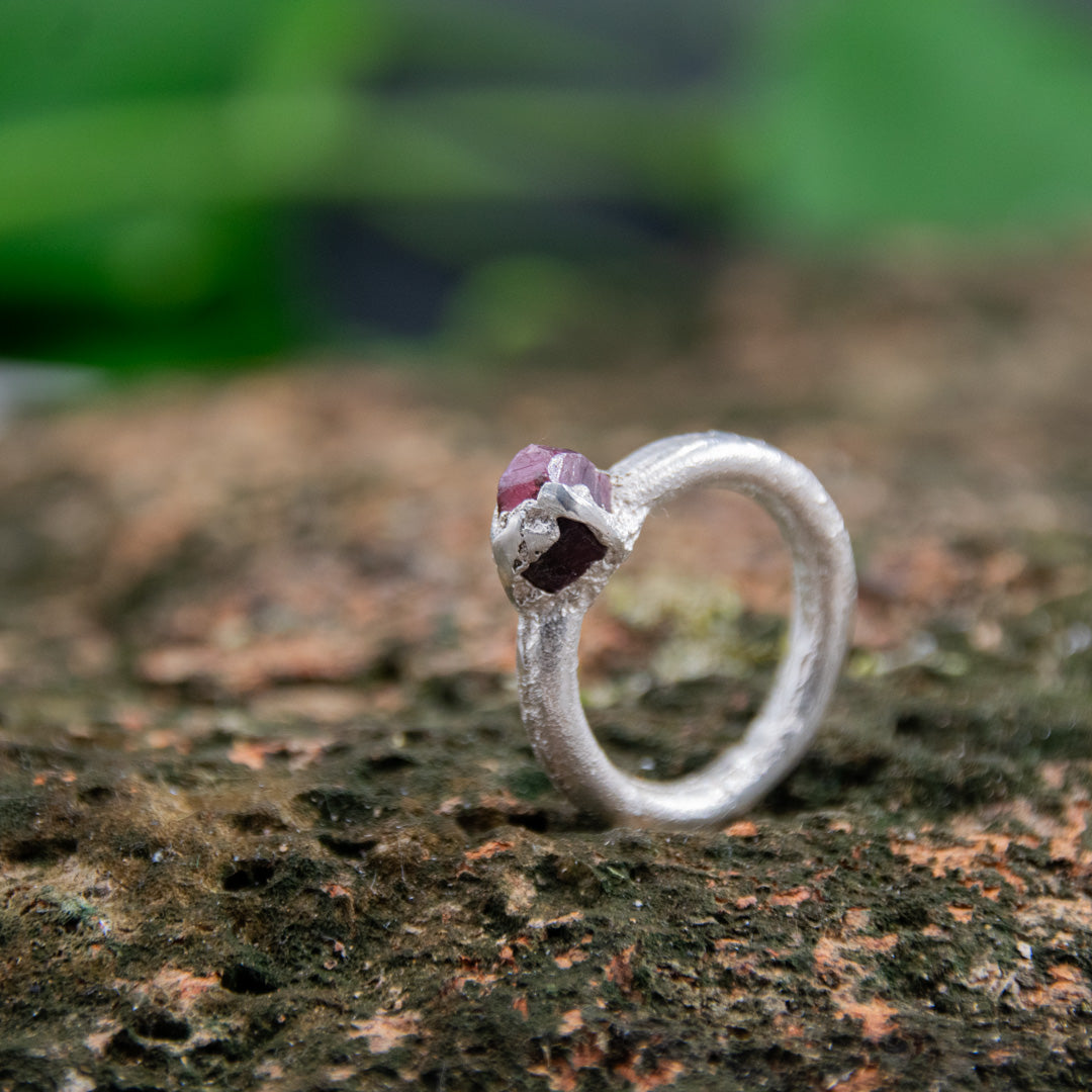 Raw ruby round ring in sand-casted silver, showcasing unique organic textures and imperfections.