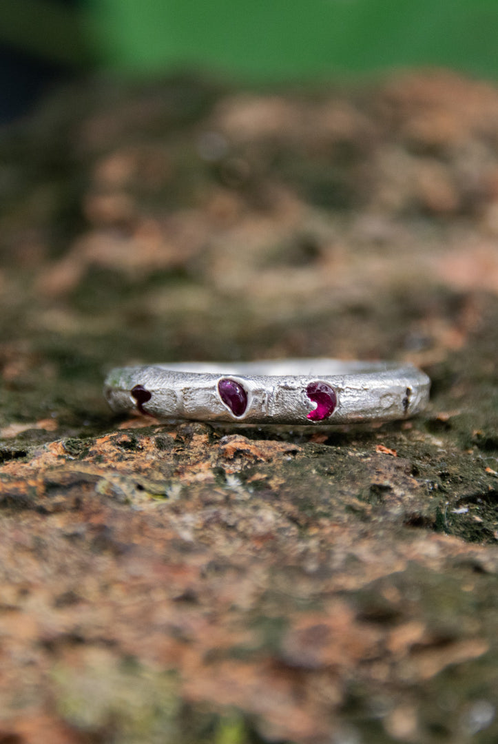 Three Little Ruby round ring in sand casting with organic texture and unique irregular shape.