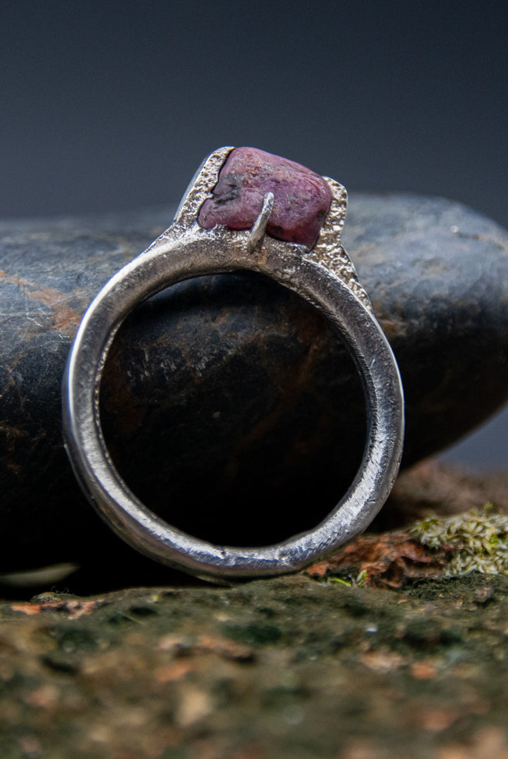 Raw ruby ring featuring a unique sandcast design, showcasing organic textures and irregular shapes.