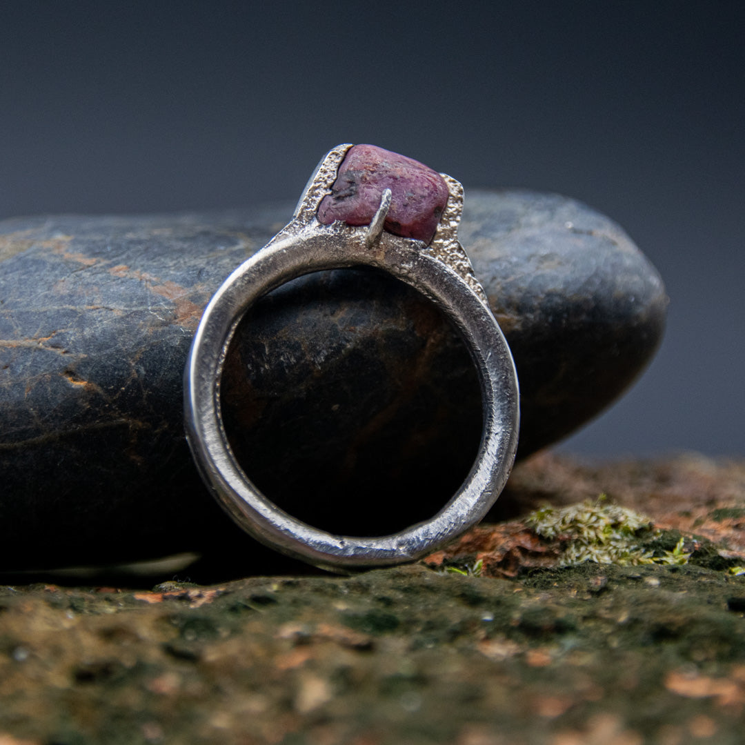 Raw ruby ring featuring a unique sandcast design, showcasing organic textures and irregular shapes.