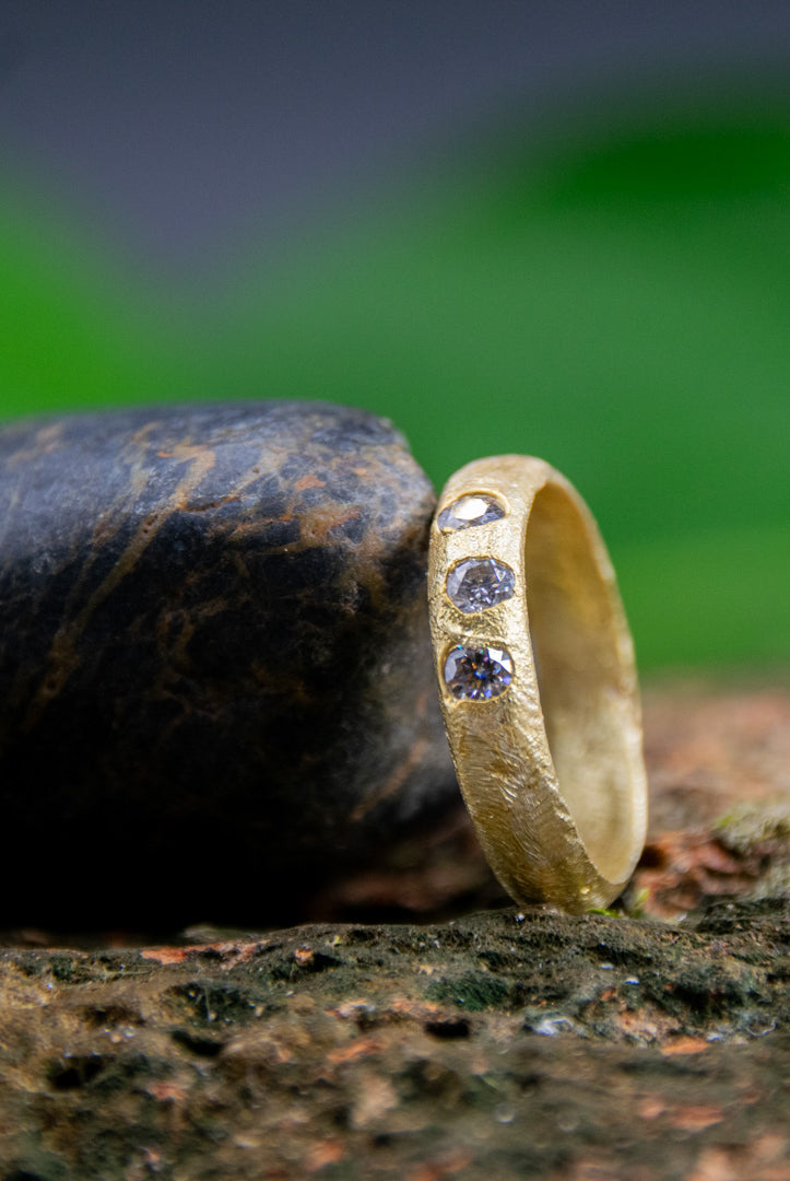 14K gold ring with moissanite stones, showcasing unique sand casting texture and artisanal craftsmanship.