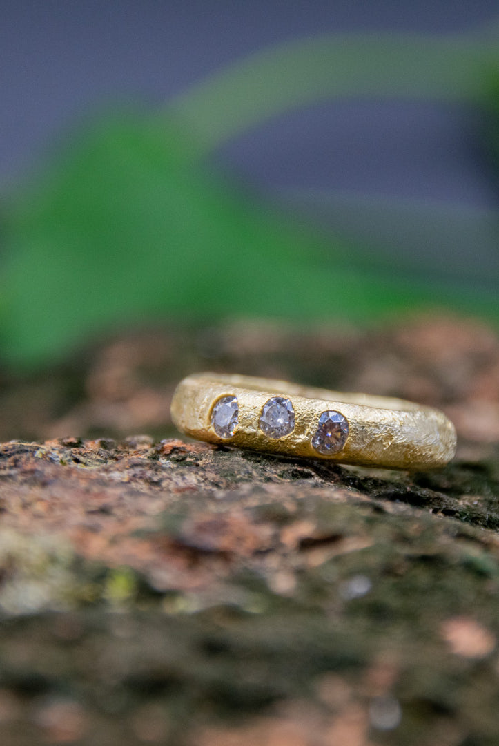 14K gold sand casting ring featuring unique moissanite gemstones, showcasing artisanal craftsmanship and organic textures.