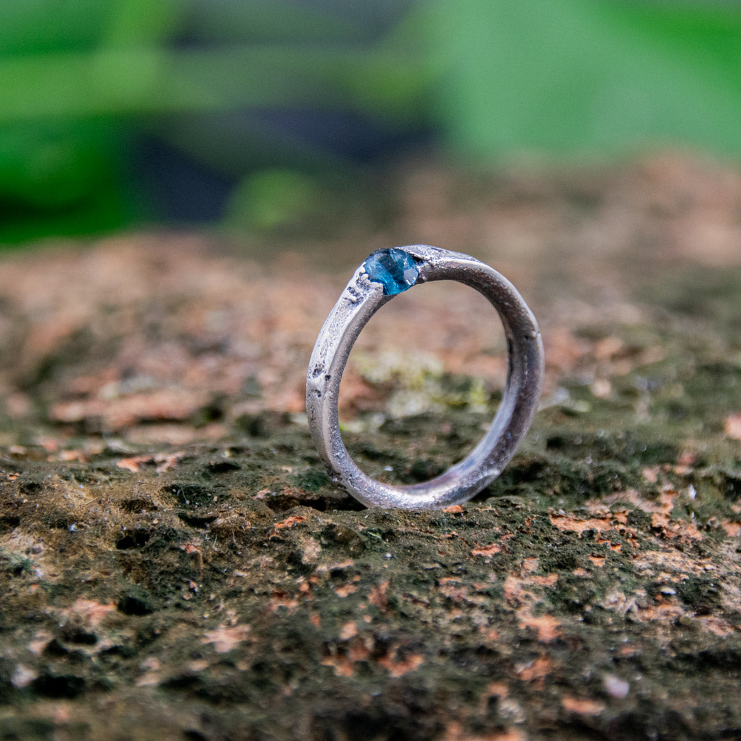 Unique blue sky zirconia sand casting ring on textured stone background, showcasing artisanal craftsmanship.
