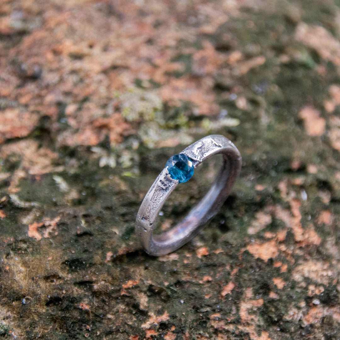 Unique Blue Sky Zirconia Sand Casting Ring with organic texture and blue stone on natural background.