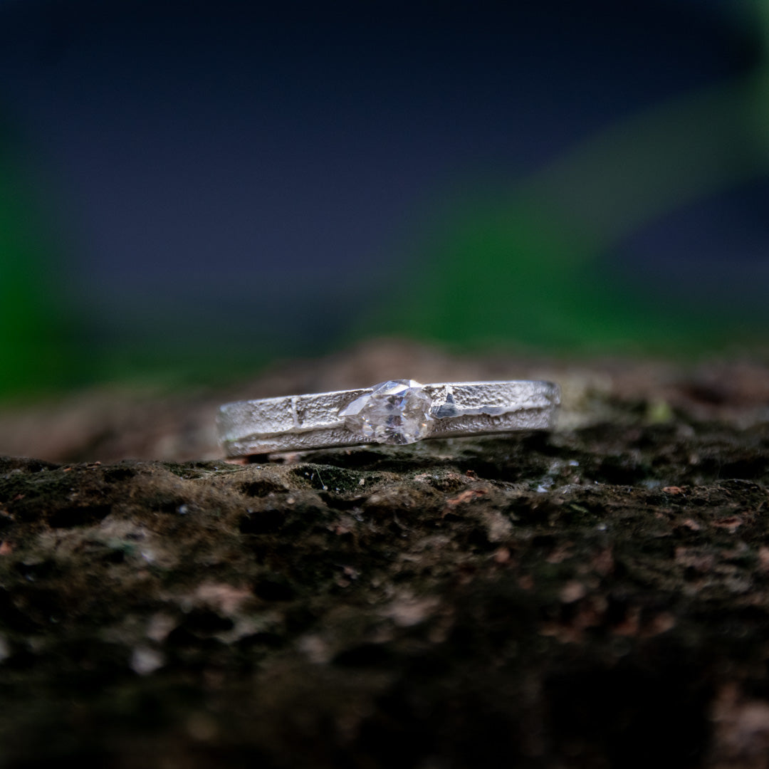 Crystal zirconia sandcasting ring showcasing unique organic textures and artisanal craftsmanship in a natural setting.
