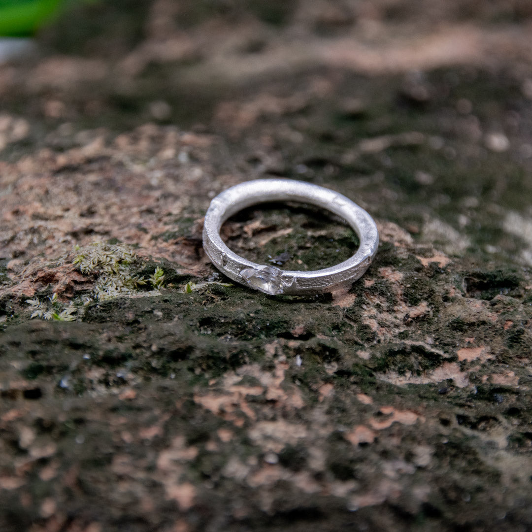 Crystal zirconia sand casting ring showcasing unique organic texture and irregular shape on textured surface.