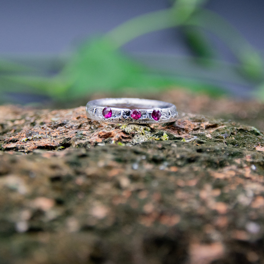 Three Little Ruby Sand Casting Ring showcasing unique textures and artisanal craftsmanship on a natural background.