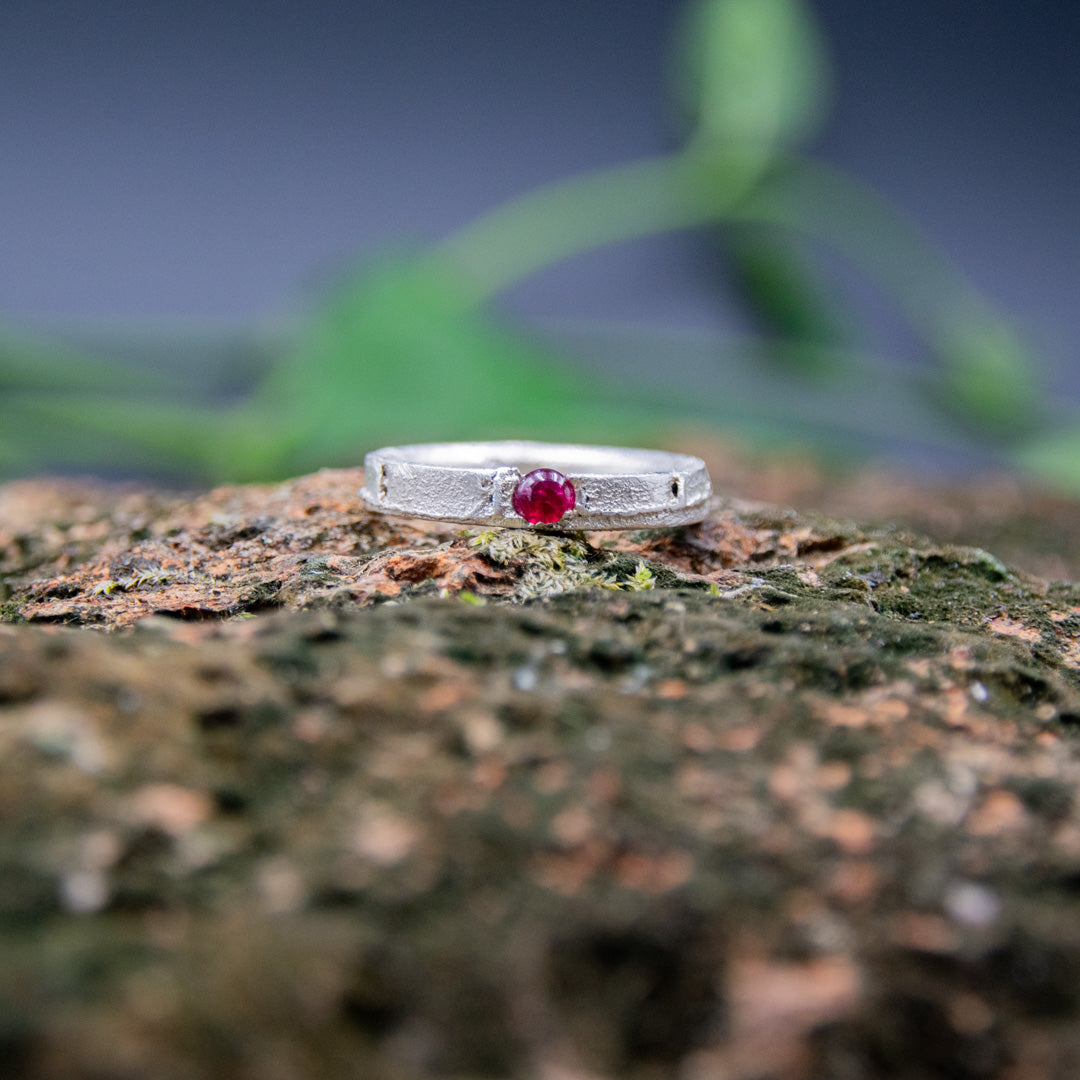 Unique round ruby sand casting ring showcasing artisanal craftsmanship and organic textures.