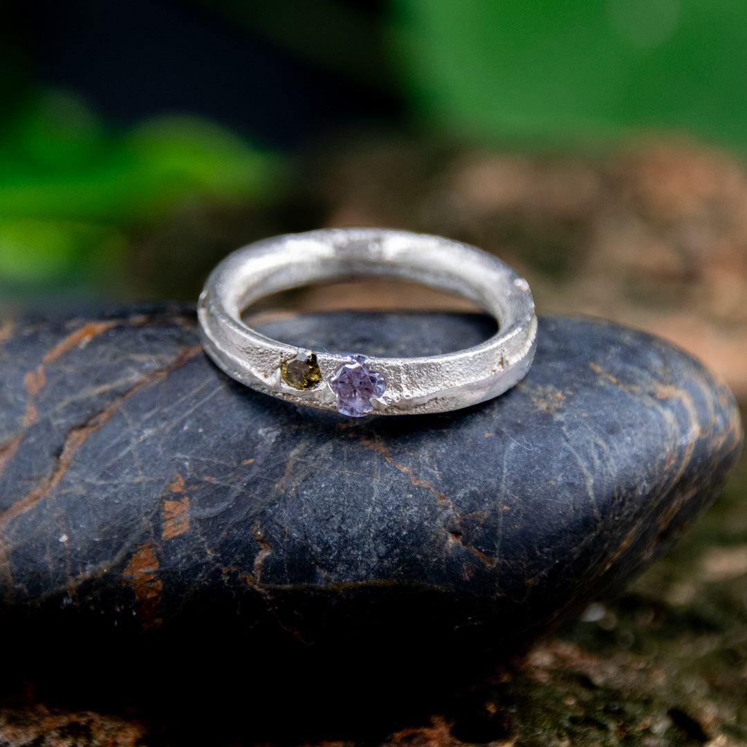 Purple and brown zirconia sandcasting ring on dark stone, showcasing unique textures and artisanal craftsmanship.