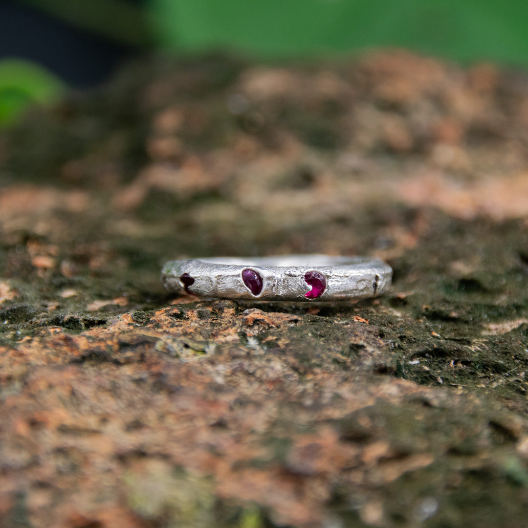 Three Little Ruby round ring in sand casting with organic texture and unique irregular shape.