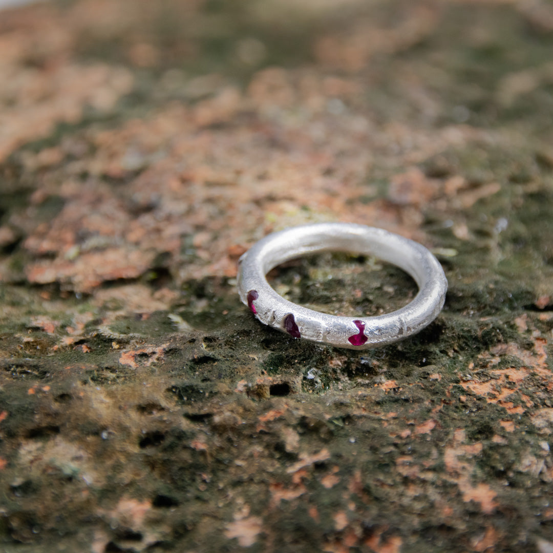 Three Little Ruby round ring crafted using sandcasting technique, showcasing unique textures and organic shapes.