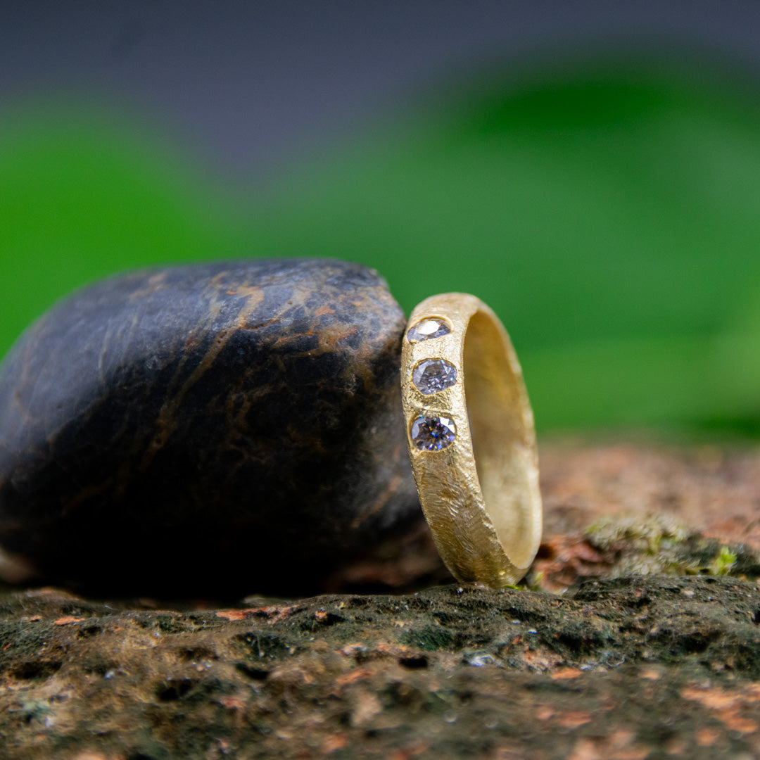 14K gold ring with moissanite stones, showcasing unique sand casting texture and artisanal craftsmanship.