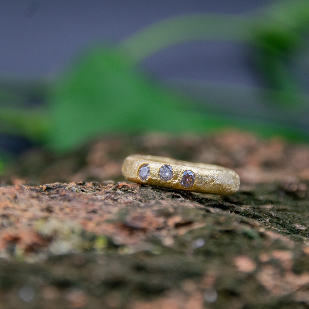 14K gold sand casting ring featuring unique moissanite gemstones, showcasing artisanal craftsmanship and organic textures.
