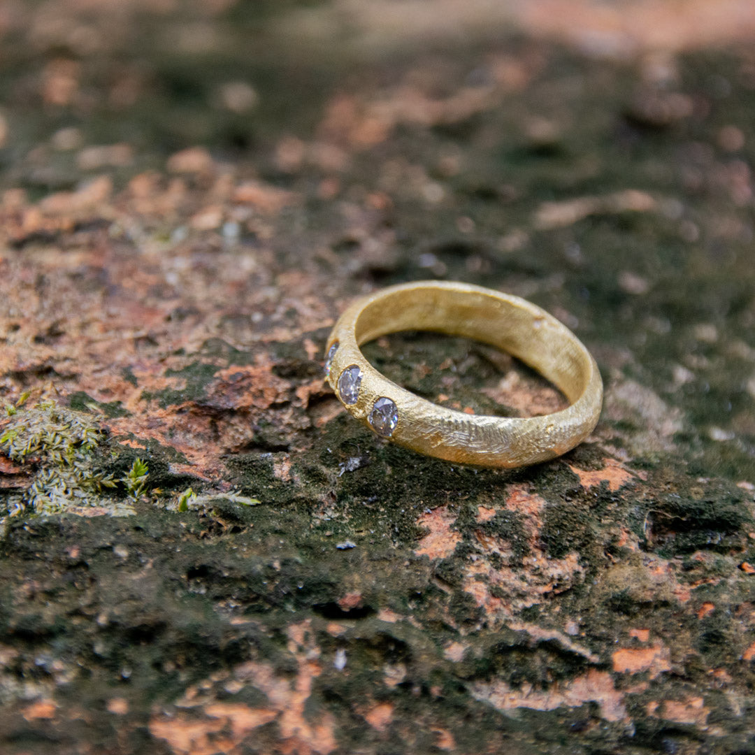 14K gold ring with moissanite, showcasing unique sandcasting technique and organic textures.